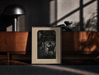 Black-framed Santa Claus seated before a fireplace print on a moody console with designer coffee-table books