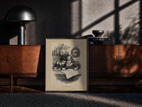 Black-framed Two children studying a map together print on a moody console with designer coffee-table books