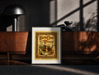 Black-framed Santa Claus sewing doll clothes in workshop print on a moody console with designer coffee-table books