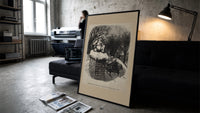 Santa Claus sitting atop snowy chimney print in a slim black frame leaning on a dark sofa in a concrete print studio