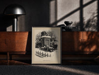 Black-framed Boy watching Santa climb a chimney print on a moody console with designer coffee-table books