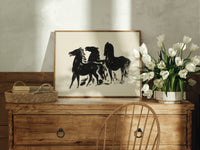 Three black horses standing print in an oak frame on a farmhouse dresser beside white tulips