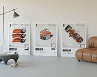 Three large sushi prints leaning on a white living room wall by a lamp and leather lounge chair