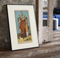 Three women toasting golden cups print in a black frame leaning beside a vintage door on parquet