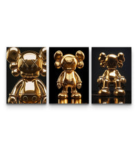 Three-panel KAWS set with polished 24K gold figures in varied poses on black backgrounds