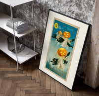 Black cats with jack-o-lantern heads poster in a black frame leaning beside a shelf in a raw-plaster loft