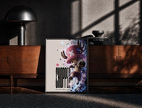 Black-framed Tony Tony Chopper anime character print on a moody console with designer coffee-table books
