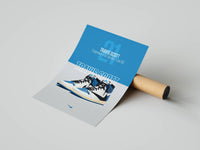 Blue and gray Jordan 1 panel with TRAVIS SCOTT lettering and a sneaker graphic unrolled beside a cardboard tube