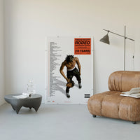 Travis Scott Rodeo Anniversary poster framed above a tan leather living-room couch