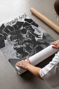 Hands unrolling a black and white Travis Scott Utopia poster with figures and text laid on concrete flooring