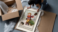Boy dragging Christmas tree on sled framed print being unpacked from protective bubble wrap and a box