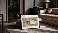 Family in snow viewing advertising signboard print in a slim black frame leaning on a travertine coffee table