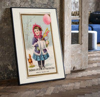 Girl in winter coat holding toys print in a black frame leaning beside a vintage door on parquet