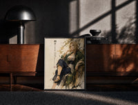 Black-framed Blonde woman seated in kimono print on a moody console with designer coffee-table books