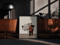 Black-framed Black Couple at a Gallery Wall print on the floor in front of a dark wooden console