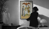 Two of Cups print in a slim black frame being hung on a sunlit wall in a monochrome room
