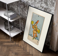 Two of Pentacles tarot figure poster in a black frame leaning beside a shelf in a raw-plaster loft