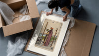 Man holding globe and staff framed print being unpacked from protective bubble wrap and a box