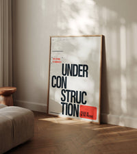 Future Under Construction poster leaning against wall in modern living room