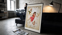 Andromeda constellation chained woman figure print in a slim black frame leaning on a dark sofa in a concrete print studio