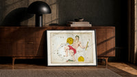 Aquarius constellation figure pouring water print in a black frame leaning against a walnut console in lamplight