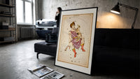Auriga constellation charioteer holding goat print in a slim black frame leaning on a dark sofa in a concrete print studio
