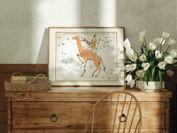 Camelopardalis constellation giraffe with figures print in an oak frame on a farmhouse dresser beside white tulips