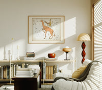 Camelopardalis constellation giraffe with figures print in an oak frame above a mid-century book console with a vintage radio