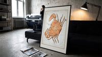 Cancer crab zodiac constellation illustration print in a slim black frame leaning on a dark sofa in a concrete print studio