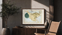 Capricornus sea-goat constellation figure print in a wood frame above a fluted sideboard beside an olive tree