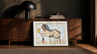 Cetus the whale constellation chart print in a black frame leaning against a walnut console in lamplight