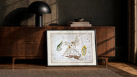 Celestial constellation star chart with animals print in a black frame leaning against a walnut console in lamplight