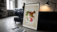 Antinous, eagle and dolphin constellations print in a slim black frame leaning on a dark sofa in a concrete print studio