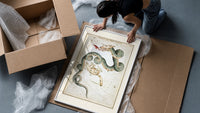 Draco dragon and Ursa Minor bear constellations framed print being unpacked from protective bubble wrap and a box