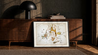 Hercules constellation star map figure print in a black frame leaning against a walnut console in lamplight
