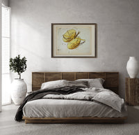 Libra constellation balance scales chart print in a dark wood frame above a rattan bed on a plaster wall