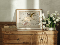 Unicorn and dog constellation illustration print in an oak frame on a farmhouse dresser beside white tulips