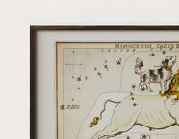 Close-up of the Unicorn and dog constellation illustration print's dark wood frame corner and archival matte paper