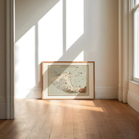 Winged horse Pegasus constellation map print in an oak frame on a sunlit wood floor beneath tall window light