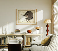 Taurus bull constellation chart print in an oak frame above a mid-century book console with a vintage radio