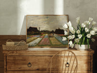 Flower fields with farmhouses print in an oak frame on a farmhouse dresser beside white tulips