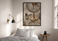 Vanity Mirror with Perfume and Jewelry print in a black frame above a bed with striped linens