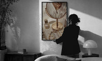 Vanity Mirror with Perfume and Jewelry print in a slim black frame being hung on a sunlit wall in a monochrome room