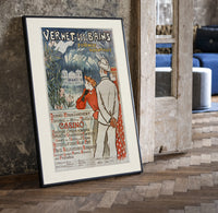 Elegant couple viewing spa resort print in a black frame leaning beside a vintage door on parquet