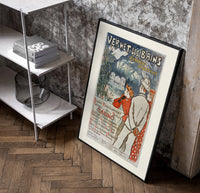 Elegant couple viewing spa resort poster in a black frame leaning beside a shelf in a raw-plaster loft