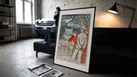 Elegant couple viewing spa resort print in a slim black frame leaning on a dark sofa in a concrete print studio