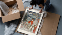 Elegant couple viewing spa resort framed print being unpacked from protective bubble wrap and a box