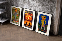 Vintage Halloween pumpkin-headed figures set of three black-framed prints leaning against a raw-plaster wall