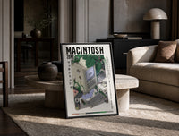 Vintage Macintosh computer with plants print in a black frame leaning on a travertine table in a sunlit lounge