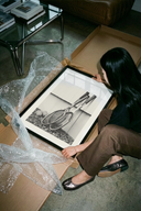 Vintage Wooden Tennis Rackets poster being unrolled on a concrete floor